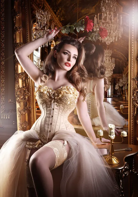 Client in white and gold gown on opulent grand staircase in ballroom setting