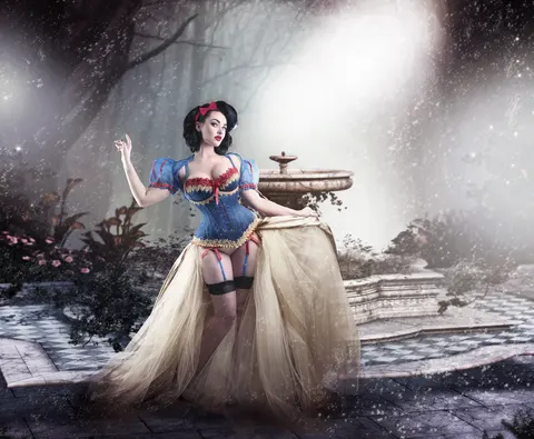 Client in Snow White-inspired corset and gown with dramatic sword prop in forest setting