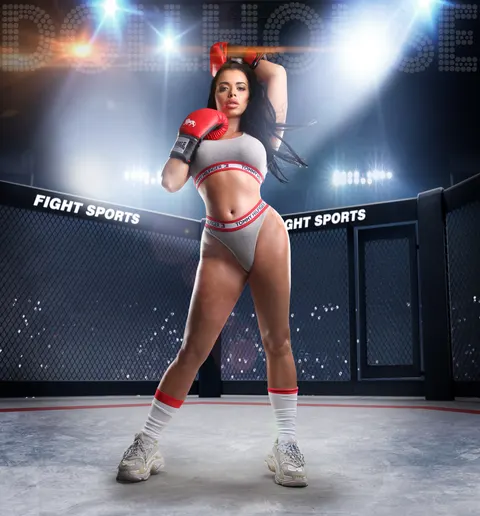 Woman in pink sports bra and red boxing gloves in professional boxing arena