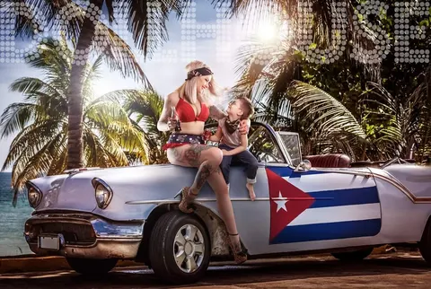 Mother with baby on vintage convertible car, Cuban tropical backdrop