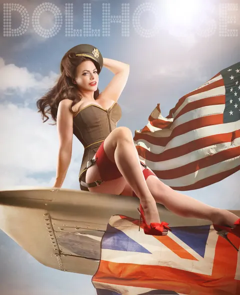 Woman in WWII military outfit on vintage aeroplane with American flag